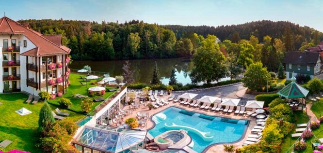 Blick aus der Höhe auf den Pool und See des Wellness Resort Romantischer Winkel im Harz, Bad Sachsa