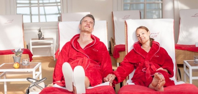 Paar entspannt in roten Bademänteln im Palmengarten des Wellness Resort Romantischer Winkel im Harz, Bad Sachsa