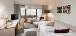 Blick ins Einzelzimmmer mit Schreibtisch und Polstersessel, Blick zum See am Wellness Resort Romantischer Winkel im Harz, Bad Sachsa