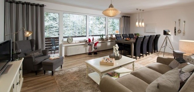 Blick ins Wohnzimmer des Genießer-Appartement des Wellness Resort Romantischer Winkel im Harz, Bad Sachsa und über den Balkon ins Grüne