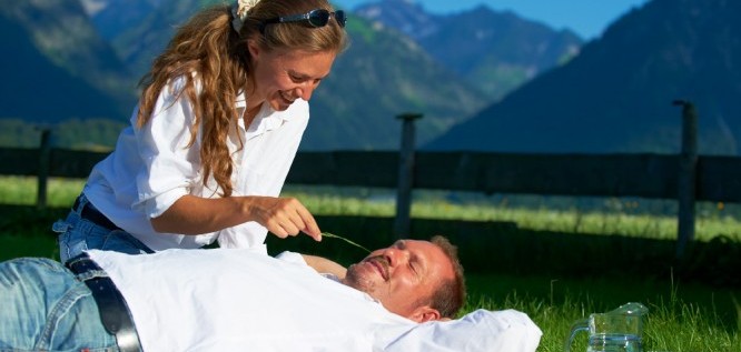 Ein Paar entspannt auf der Wiese im Garten – Schüle's Gesundheitsresort & Spa | Allgäu | Bayern